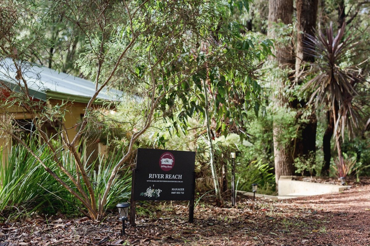 River Reach sign at the entrance among tall trees