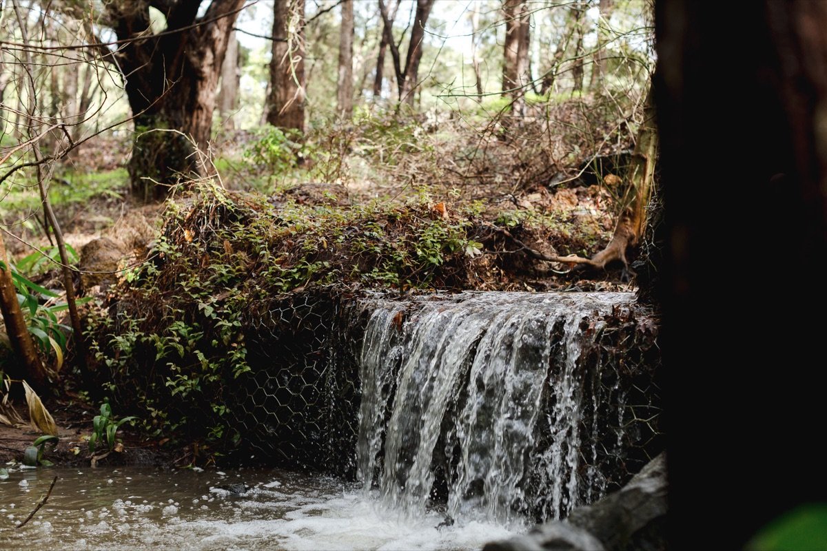 Water cascading over a small weir on the stream below the chalet