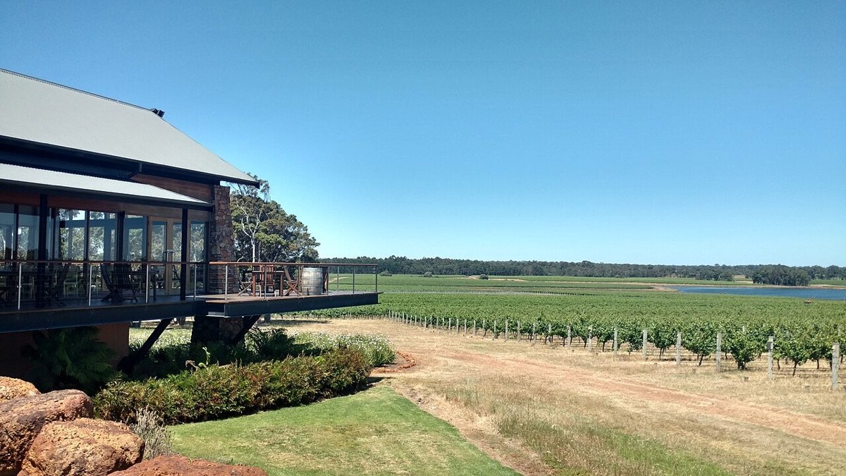 Vineyard rows and a cellar door deck in Margaret River wine country